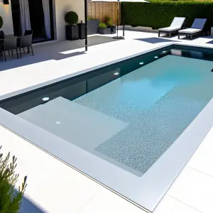 A modern backyard featuring a sleek fiberglass pool with clean, smooth edges The pool is rectangular, surrounded by elegant stone decking