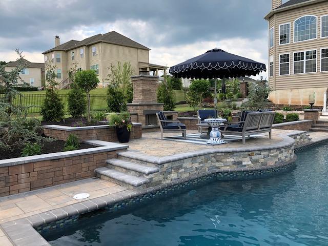 Raised poolside seating area connected by wide stone steps